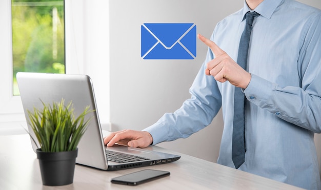 Businessman hand holding e-mail icon, Contact us by newsletter email and protect your personal information from spam mail. Customer service call center contact us concept.