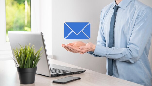 Businessman hand holding e-mail icon, Contact us by newsletter email and protect your personal information from spam mail. Customer service call center contact us concept