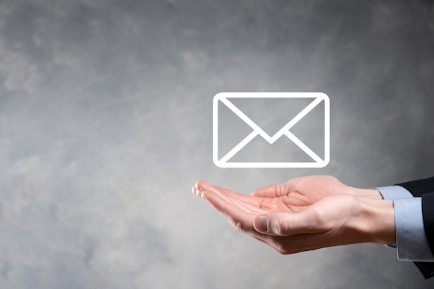 Businessman hand holding e-mail icon, Contact us by newsletter email and protect your personal information from spam mail