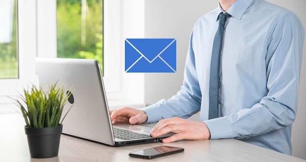 Businessman hand holding email icon Contact us by newsletter email and protect your personal information from spam mail Customer service call center contact us concept