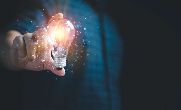 ネットワークの概念とインスピレーションと革新のための創造的なスマートな思考に輝く光で電球を持っているビジネスマンの手