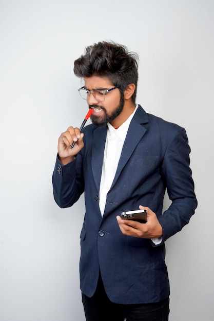 Businessman hand holding mobile phone and marker standing\
isolated on white background man in suit writing using phone\
thinking video call conversation