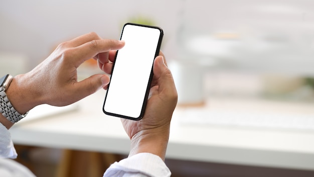 Businessman hand holding mobile smartphone in office