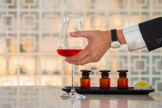 テーブルの上の赤ワインのグラスを持っているビジネスマン手