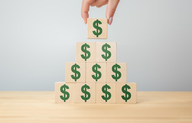 Businessman hand holding wooden blocks with the American Dollar symbol. Money, cash, currency and investment concept. Business growth, increase profit, increase income or saving concept.