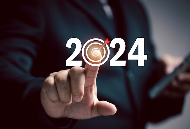 ビジネスマンは、2024 年のターゲットを指しています。翌年のマーケティング計画。設定目標の目標ビジネスコストと予算計画のための会社の成長です。