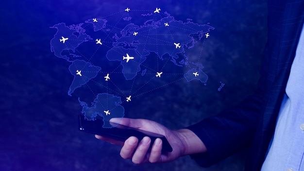 Photo businessman hand pushing flight booking networking with smart phone hand pressing light blue world map with flight routes airplane on blue background transportation concept