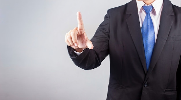 Businessman hand pushing on touch screen interface over gray background