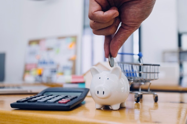 Businessman hand putting coin in piggy bank Saving money concept business finance and investment