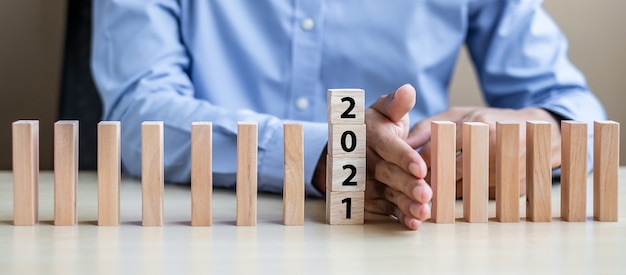 Businessman hand Stopping Falling wooden Blocks