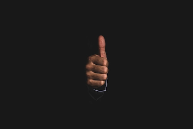 Businessman hand thumb up or like to good signal on black background.