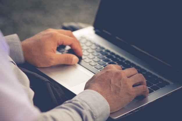 businessman hand typing on laptop keyboard