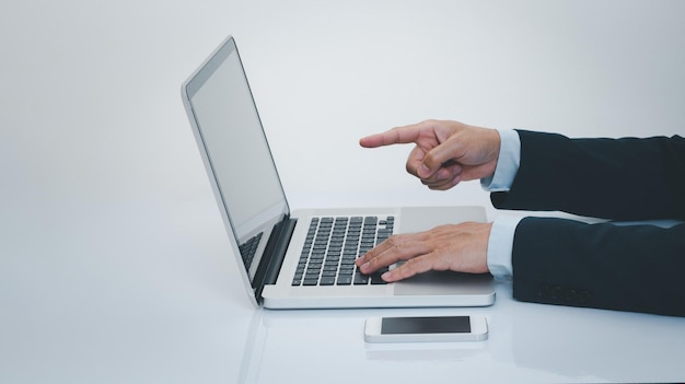 Businessman hand using smartphone with laptop computer Business and technology concept