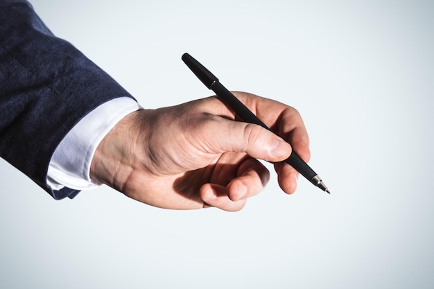 Photo businessman hand with pen isolated on blue background business and education concept close up