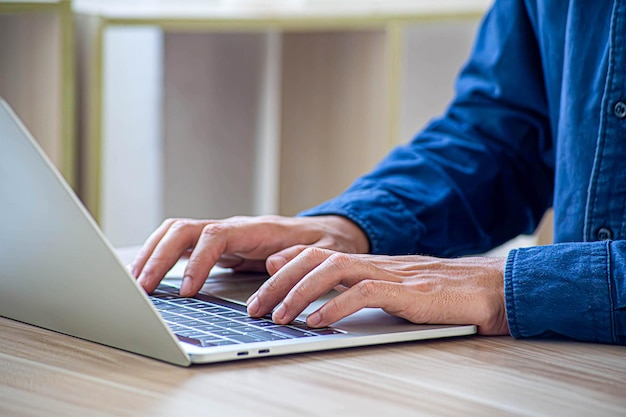 Businessman hand work on capable laptop computer at office table close up shot and selective focus