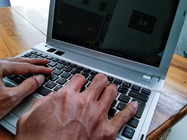 Businessman hand working with laptop on wooden table