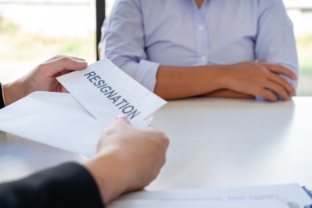 Businessman handing a resignation letter to the executive employer