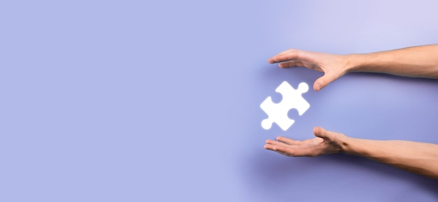 Businessman hands connecting puzzle pieces representing the merging of two companies or joint venture, partnership, Mergers and acquisition concept.