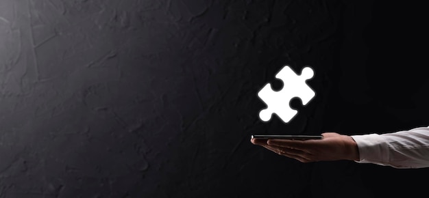 Businessman hands connecting puzzle pieces representing the merging of two companies or joint venture, partnership, Mergers and acquisition concept.