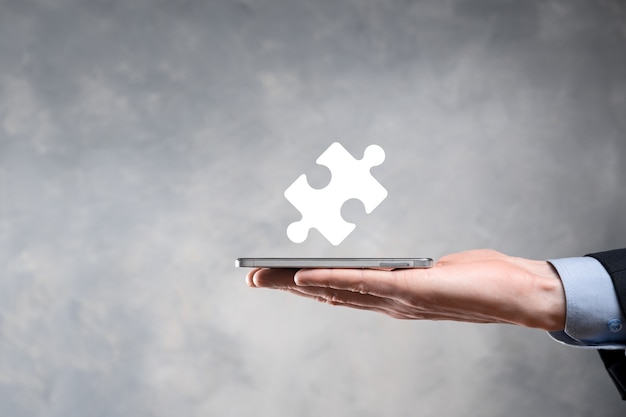 Businessman hands connecting puzzle pieces representing the merging of two companies or joint venture, partnership, Mergers and acquisition concept.