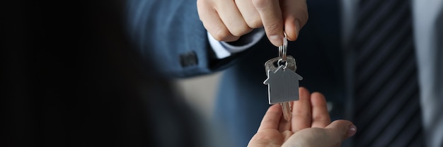 Photo businessman hands over house keys to client