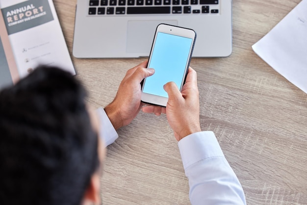 Businessman hands and phone screen above for social media communication or networking at the office Top view hand of man employee typing or texting on mobile smartphone mockup display at workplace