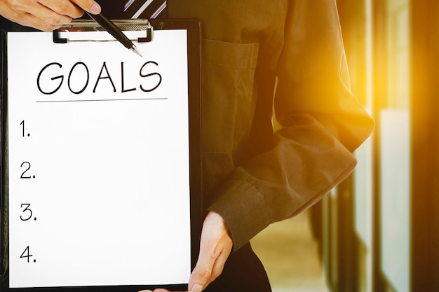 Businessman hands show goals list on clipboard
