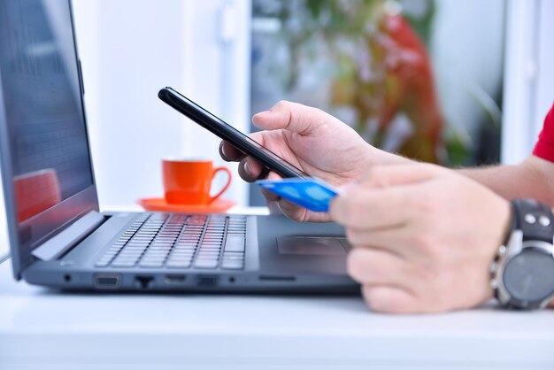 Businessman hands using smarthone and holding credit card