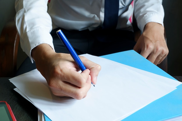 businessman hands writing on paper , freelancer man working, filtered image, cross process, flare sun light