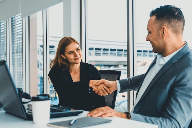 Businessman handshake businesswoman in office uds