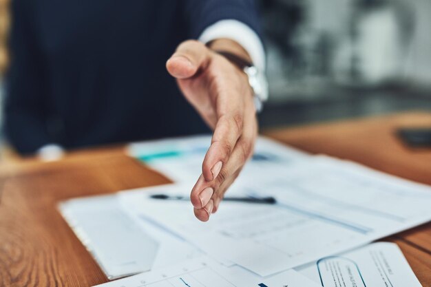 Foto stretta di mano dell'uomo d'affari e incontro per un accordo b2b o documento in ufficio impiegato uomo che stringe la mano per il saluto di presentazione o l'assunzione nel reclutamento per la crescita aziendale sul posto di lavoro