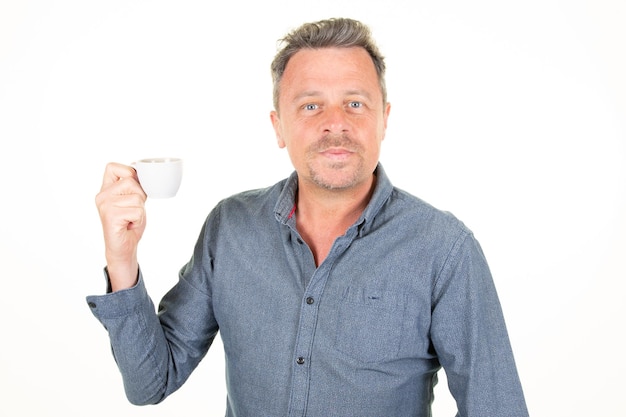 Photo businessman handsome attractive man wearing blue shirt drinking hot drink coffee from cup isolated over white background