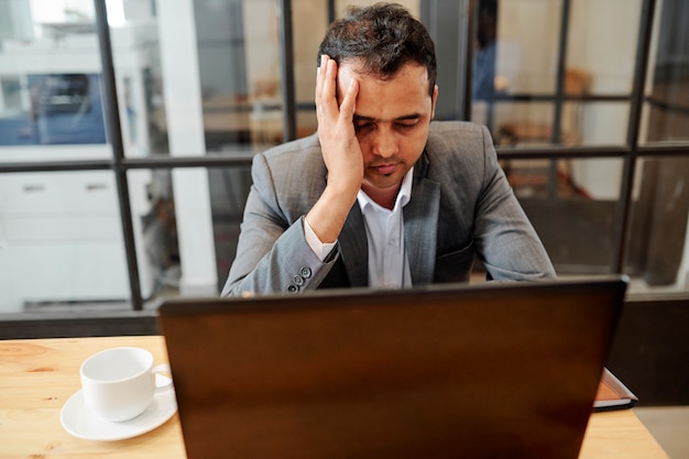 Businessman has a headache during work day