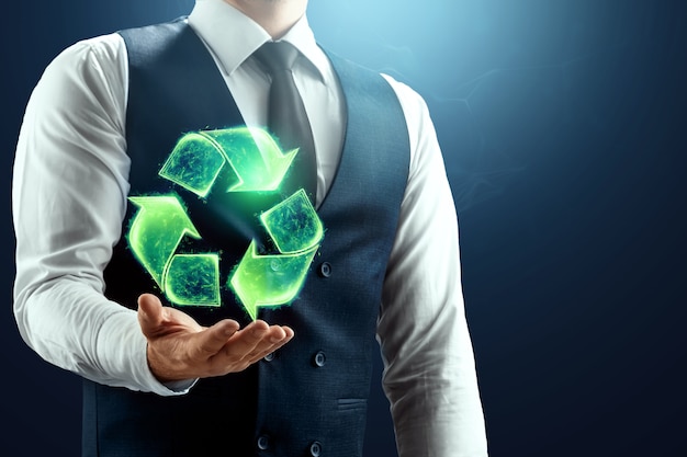 the businessman has a hologram of the recycling icon in the palm of his hand