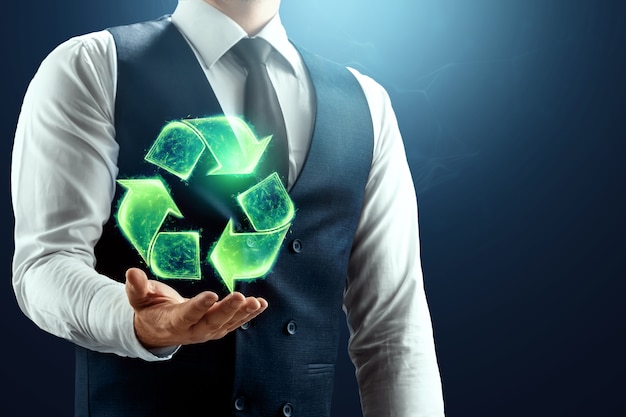 The businessman has a hologram of the recycling icon in the palm of his hand