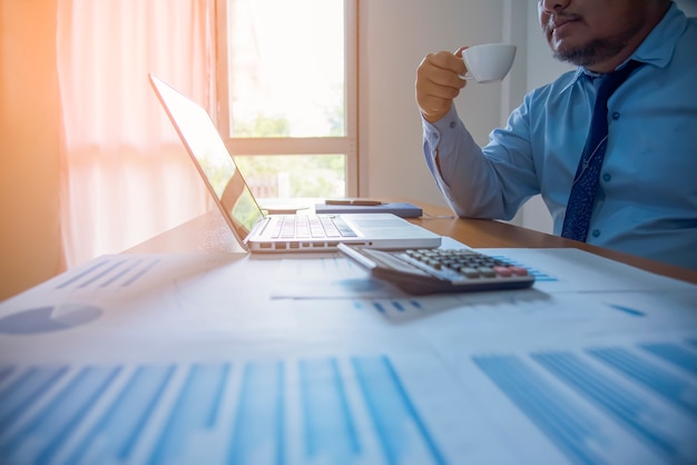 Businessman having coffee break, he is holding a cup