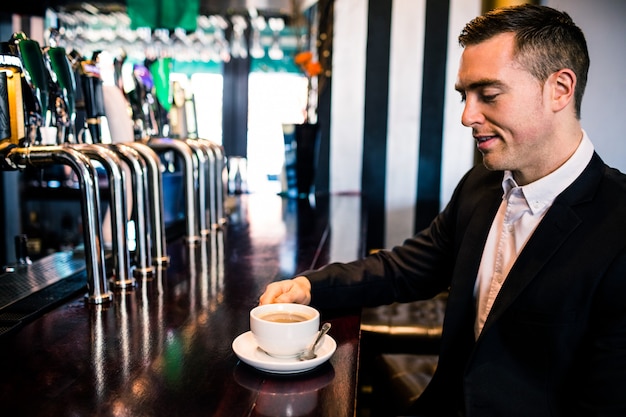 Businessman having a coffee at the counter in a bar