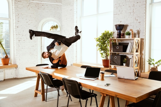 Photo businessman having fun dancing break dance in the office at work