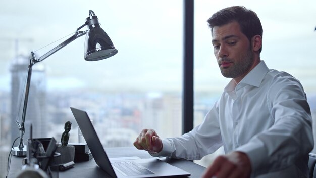 Businessman having video call on laptop in office Man looking at graphs