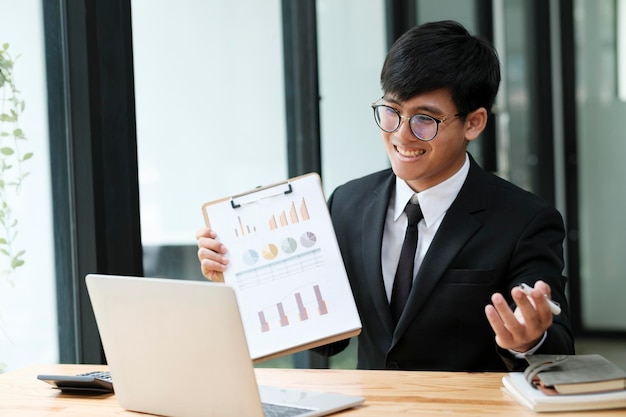 Businessman having video call with client and holding graph paper