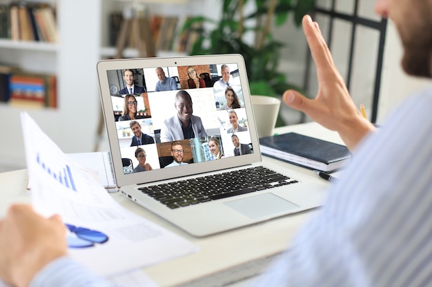 Photo businessman in headphones talking to her colleagues in video conference