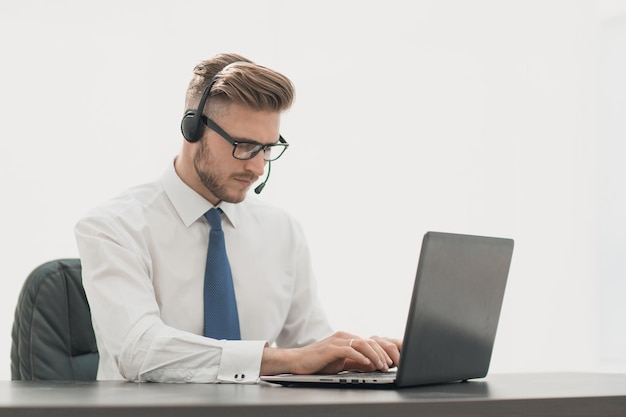Businessman in headphones working on a laptopphoto with copy space