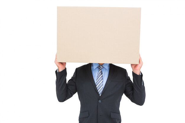 Businessman hiding head with a box