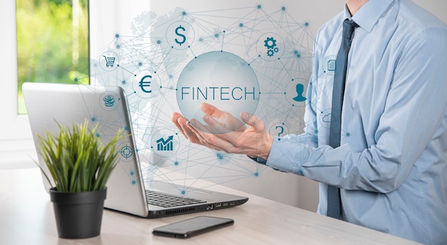 Uomo d'affari tenere fintech - concetto di tecnologia finanziaria. pagamento bancario di investimento aziendale. investimenti in criptovalute e denaro digitale. concetto di affari sullo schermo virtuale.