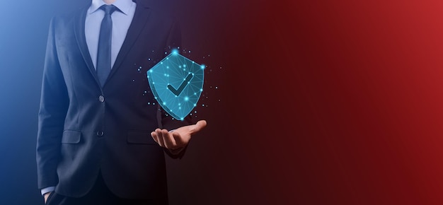 Businessman hold low poly polygon shield with a tick icon.Secure Access System Concept.Business Financial Warranty for Investment.antivirus concept.Technology security.Protection network,safe data.