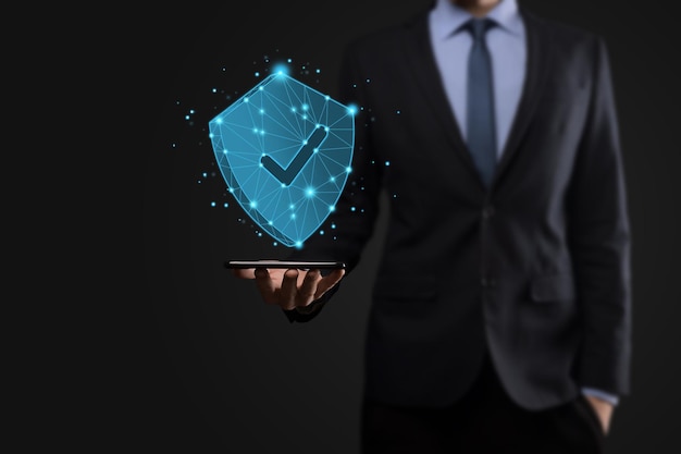 Businessman hold low poly polygon shield with a tick icon.Secure Access System Concept.Business Financial Warranty for Investment.antivirus concept.Technology security.Protection network,safe data.