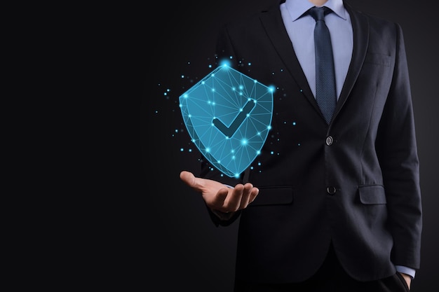 Businessman hold low poly polygon shield with a tick icon.Secure Access System Concept.Business Financial Warranty for Investment.antivirus concept.Technology security.Protection network,safe data.