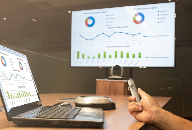 Businessman hold remote control slide with mock up chart presentation on display television