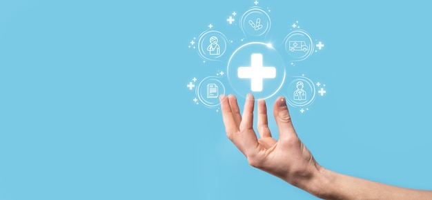 Businessman hold virtual plus medical network connection icons. Covid-19 pandemic develop people awareness and spread attention on their healthcare.Doctor,document,medicine,ambulance,patient icon.