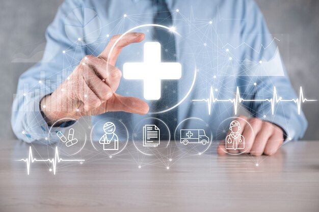 Businessman hold virtual plus medical network connection icons. Covid-19 pandemic develop people awareness and spread attention on their healthcare.Doctor,document,medicine,ambulance,patient icon.